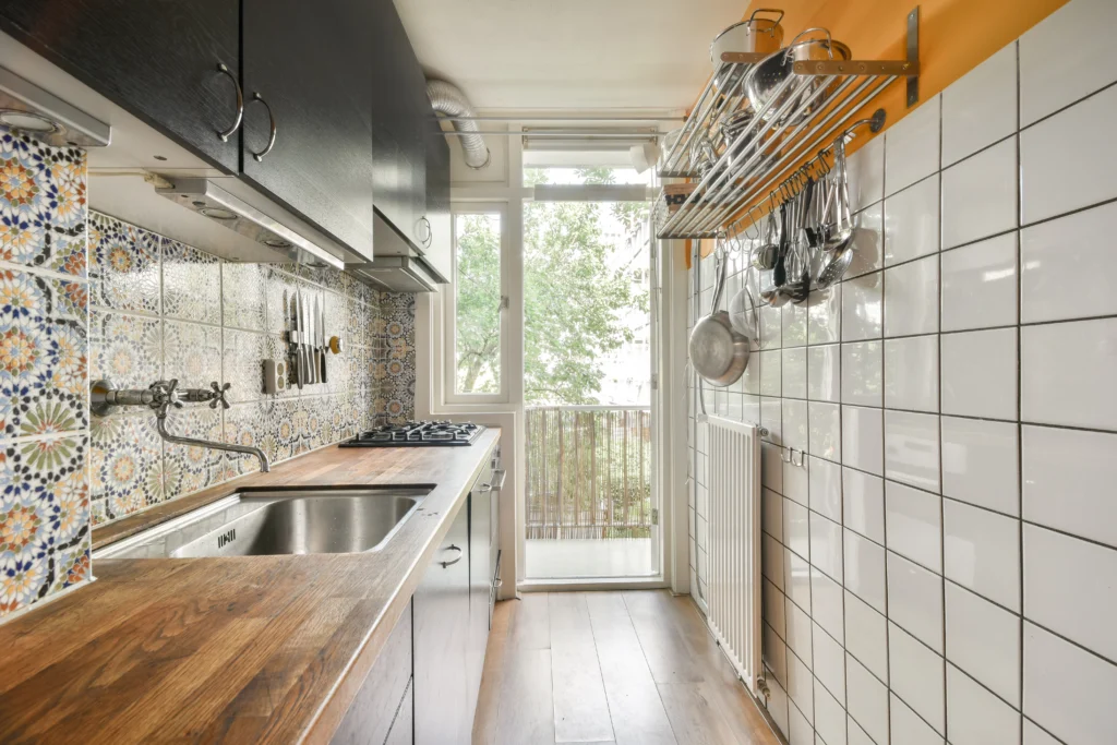 A modern white kitchen design showcasing Small Kitchen Remodel Ideas, featuring a sleek island, minimalist cabinetry, and integrated lighting to maximize a narrow space.