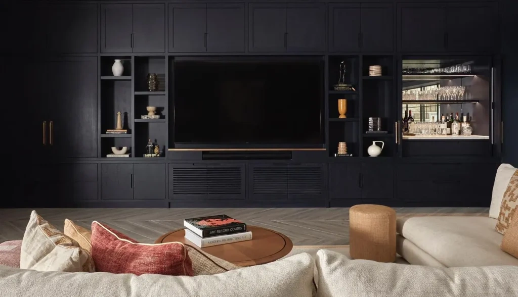 A modern 2026 interior featuring a custom black entertainment wall with integrated LED lighting, highlighting the high-end results of Planning Your San Diego Remodel with a Room Addition.